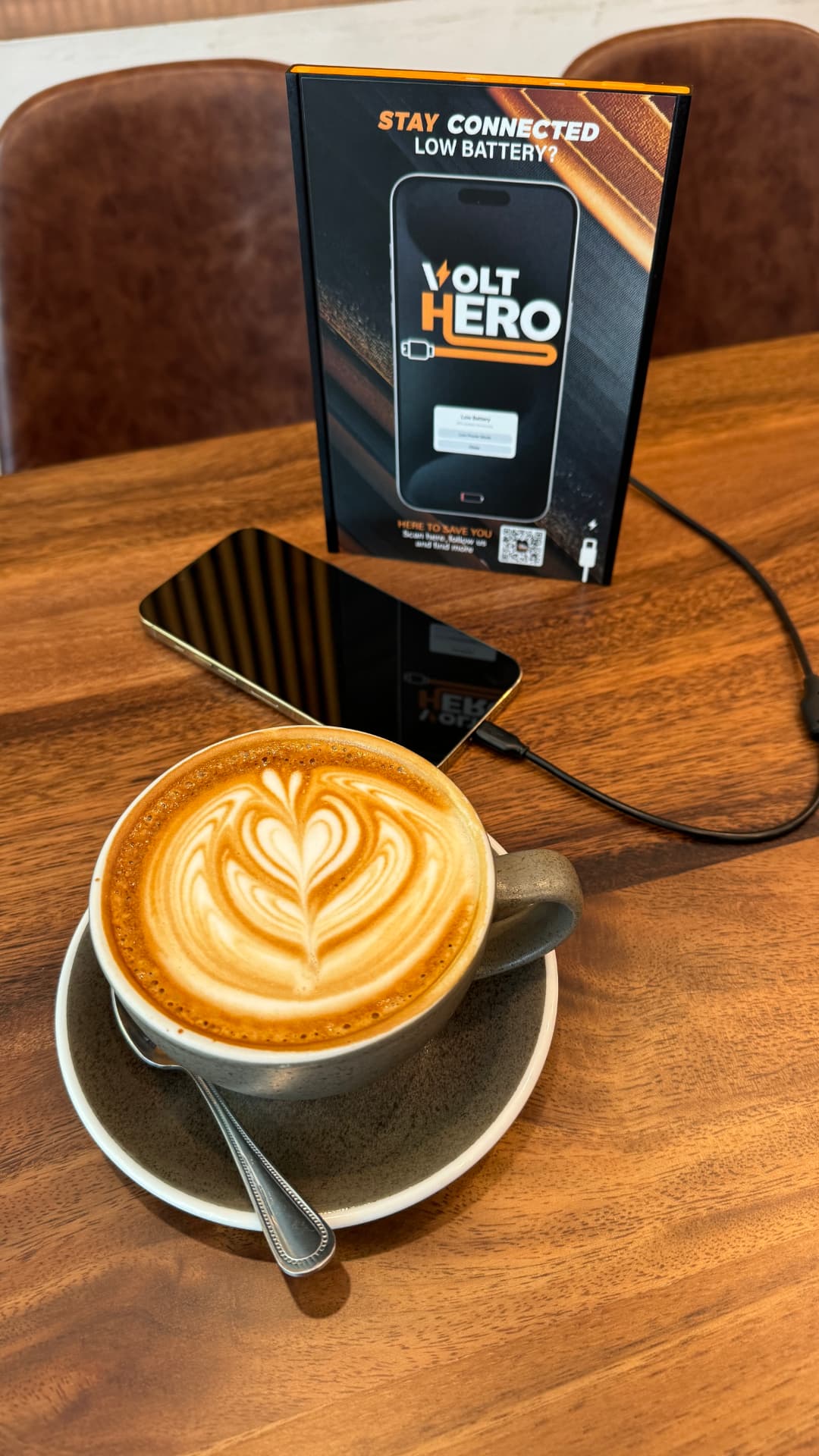 Phone charging with a VOLT HERO power bank at a table